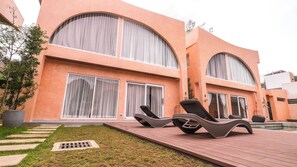 Un bâtiment moderne doté de grandes fenêtres et d’un espace piscine.