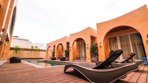 A poolside area with lounge chairs, a pool, and arched walkways. - Villa Sorrento by SMS Hospitality (San Antonio)