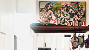 Une cuisine moderne avec des meubles blancs, un escalier en bois et un coin repas équipé de trois chaises.
