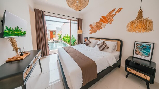 Een moderne hotelkamer met een groot bed, een televisie, een nachtkastje en uitzicht op een buitenzwembad.