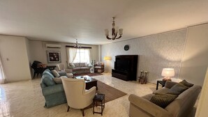 Una sala de estar amplia con un televisor grande, asientos cómodos y una chimenea.