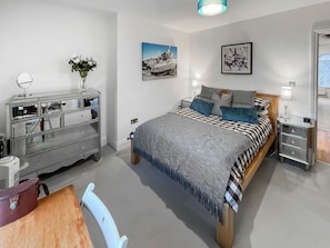 A bedroom with a bed, bedside tables, a dresser, and a mirror. - Modern coastal escape, 2 minutes from the beach, cafés and bars. (St. Leonards-on-Sea)