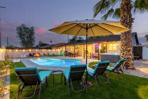 Ein Garten mit Swimmingpool, Sitzgelegenheit im Freien und Whirlpool.