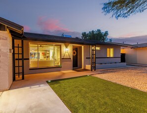 Ein modernes Haus mit gepflegtem Rasen, einer Garage und einer auffälligen Auffahrt.
