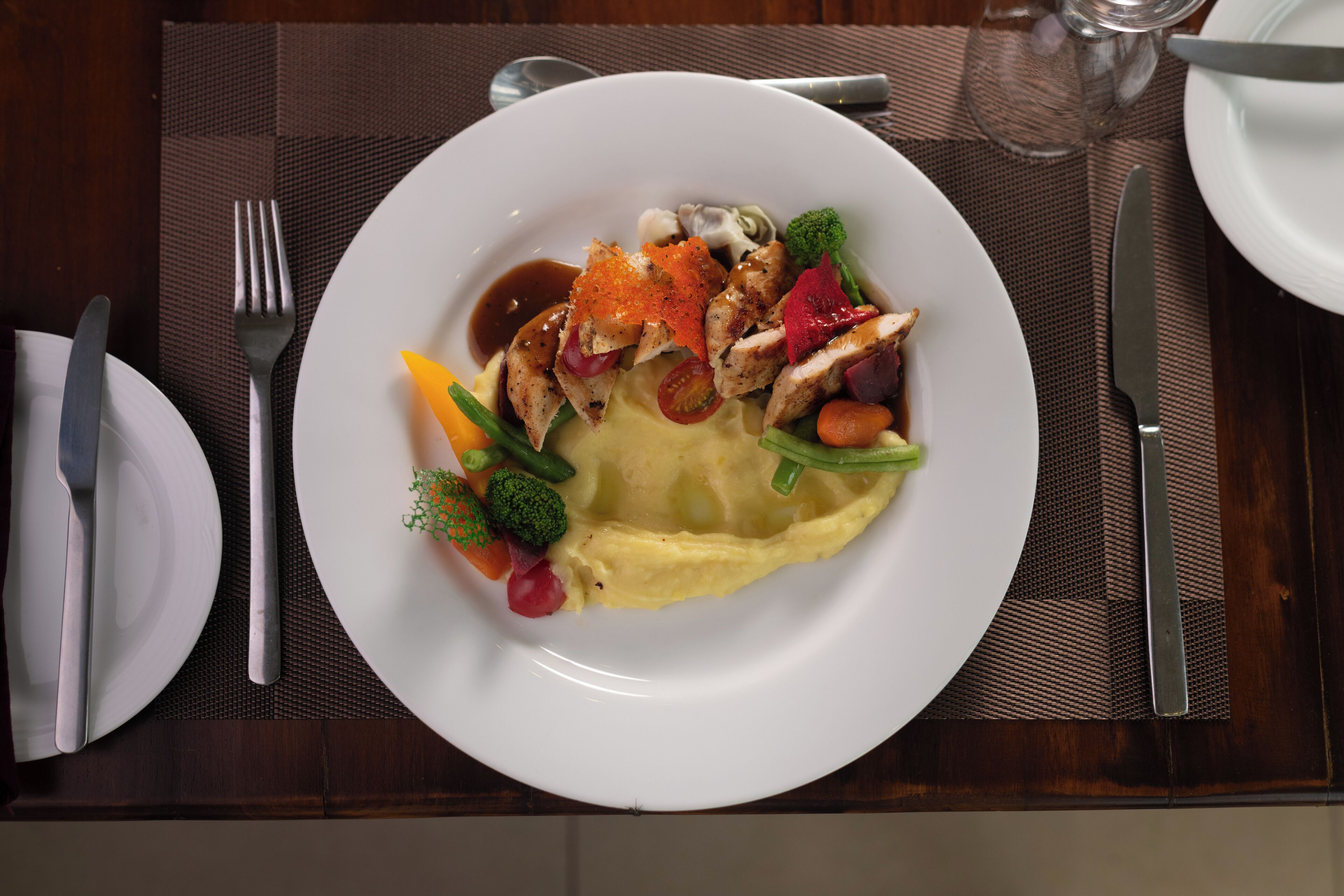 A plate of food with various vegetables and a slice of omelette on a white plate.