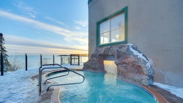 A pool with a stone wall and a view of the sunset. - Pool Access: North Shore Gem Near Beaches & Trails (Two Harbors)