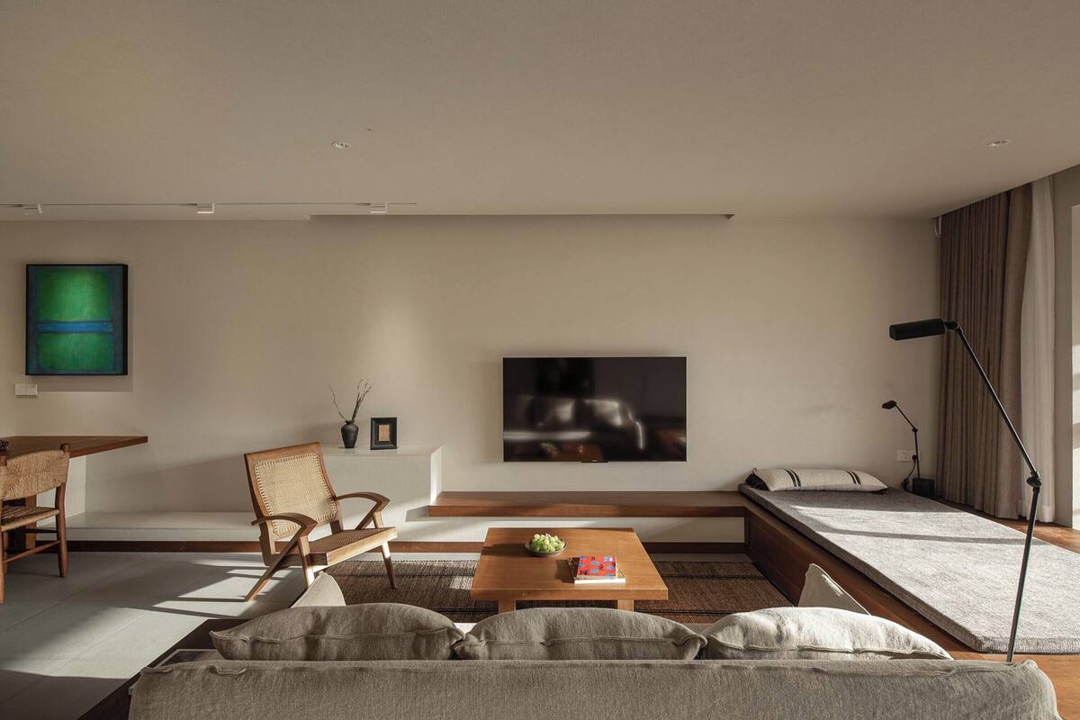 Una sala de estar moderna con un sofá, una mesa de centro, un televisor y un comedor.