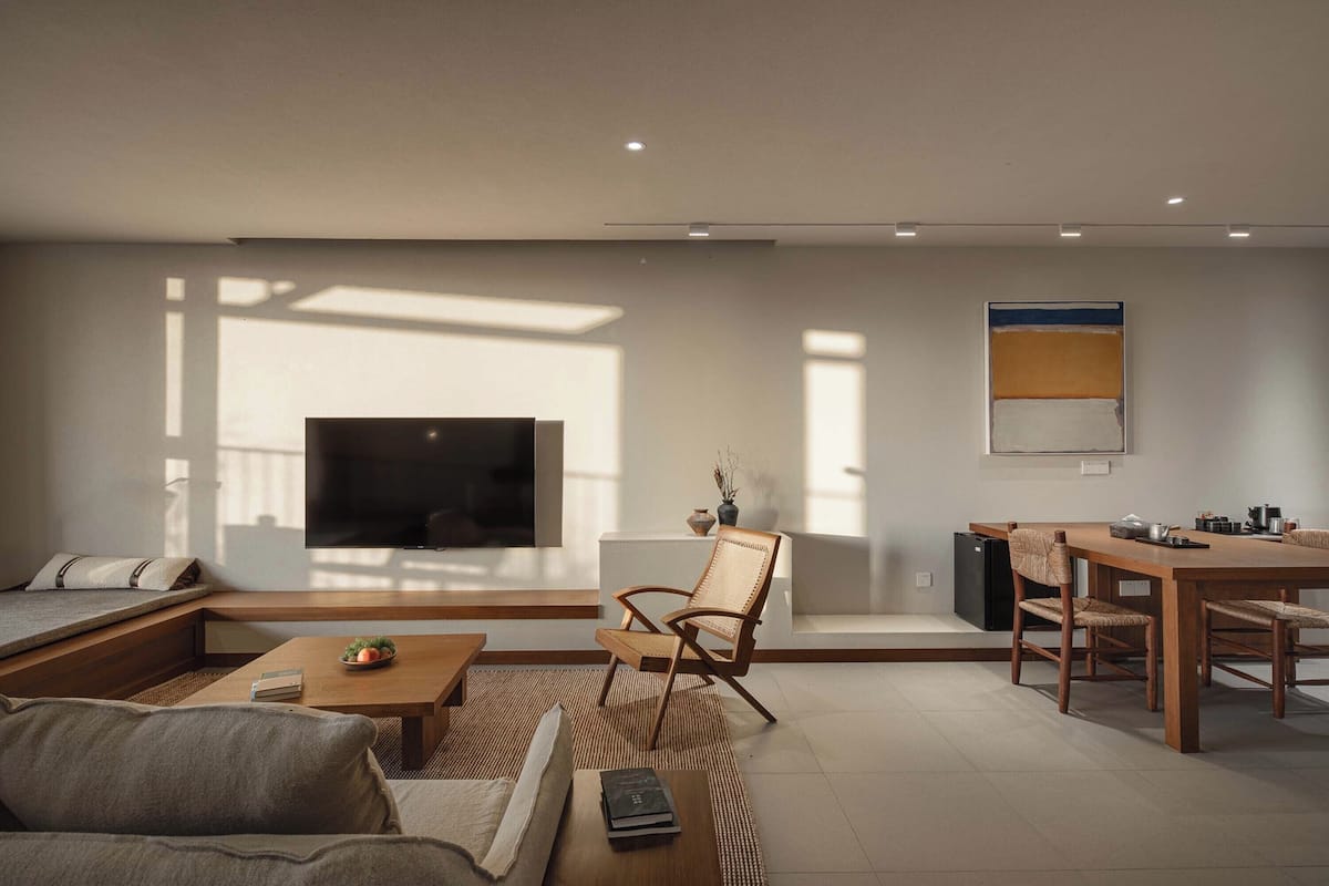 Una sala de estar moderna con un televisor de pantalla plana grande, un comedor y un sofá.
