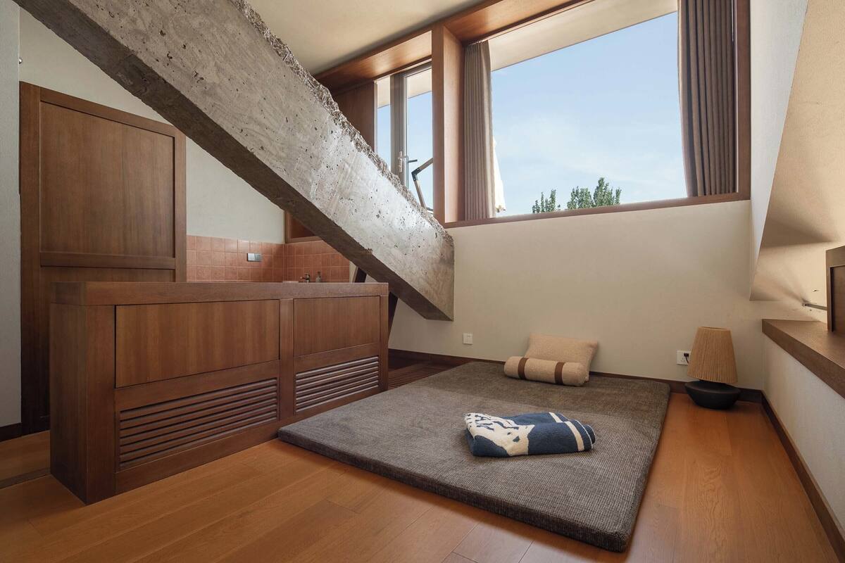 Un interior moderno con una encimera de madera, un sofá y una ventana con cortinas.