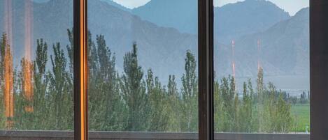 A modern room with a large window overlooking a mountainous landscape.