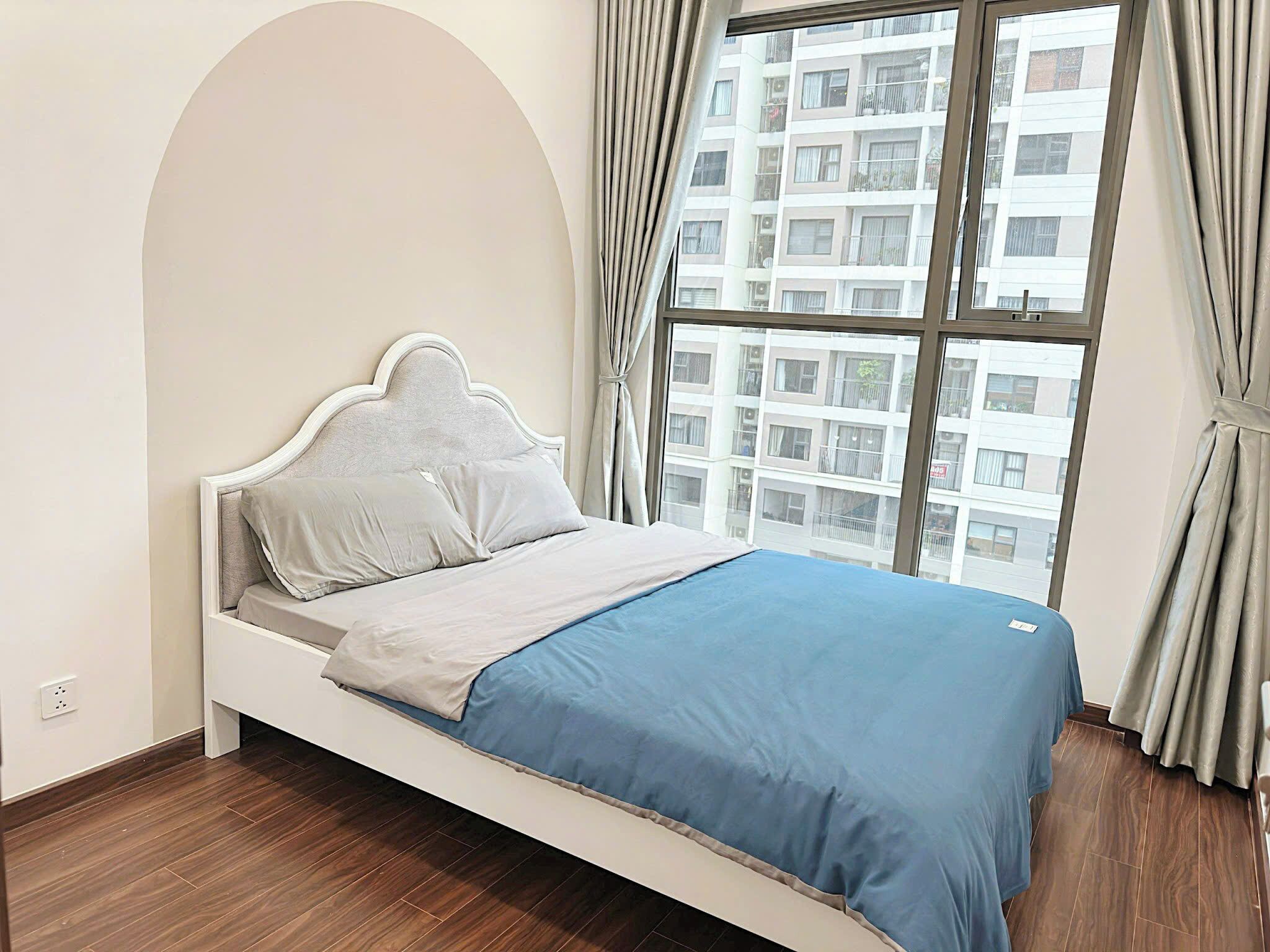 A bedroom with a bed, a window, and curtains.