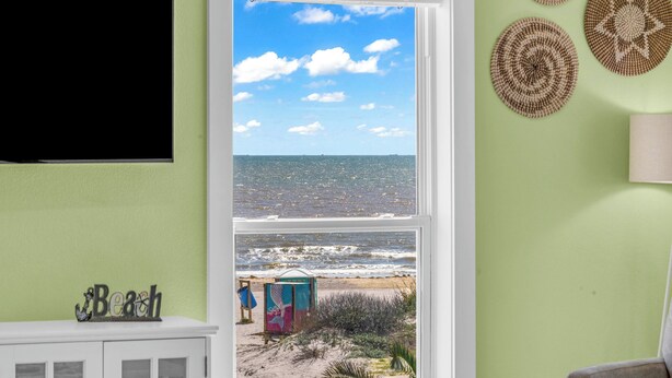 Ein Zimmer mit Blick auf den Strand, einem Schrank und Wanddekoration.