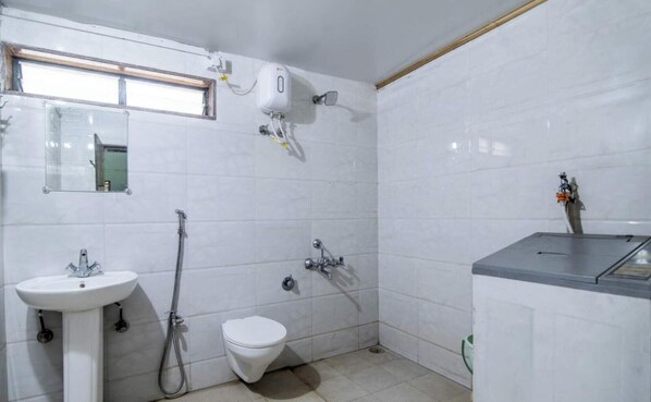 A bathroom with a sink, toilet, shower, and a mirror. - Green Living Farm House (Trimbak)