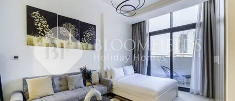 A modern hotel room with a sofa, a bed, a round coffee table, and a large window with curtains.