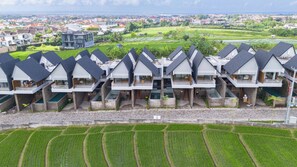 A modern hotel with multiple units featuring balconies and a view of the surrounding landscape. - Nava Tamora by Betterplace (Canggu)