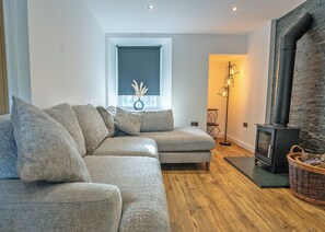 Una sala moderna con un sofá, una chimenea y una lámpara de pie.