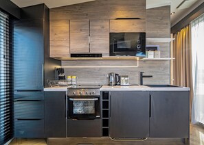 A modern kitchen with built-in appliances, a microwave, a coffee machine, and a toaster. - Kestrel Retreat S-Pod 4 (Millom)