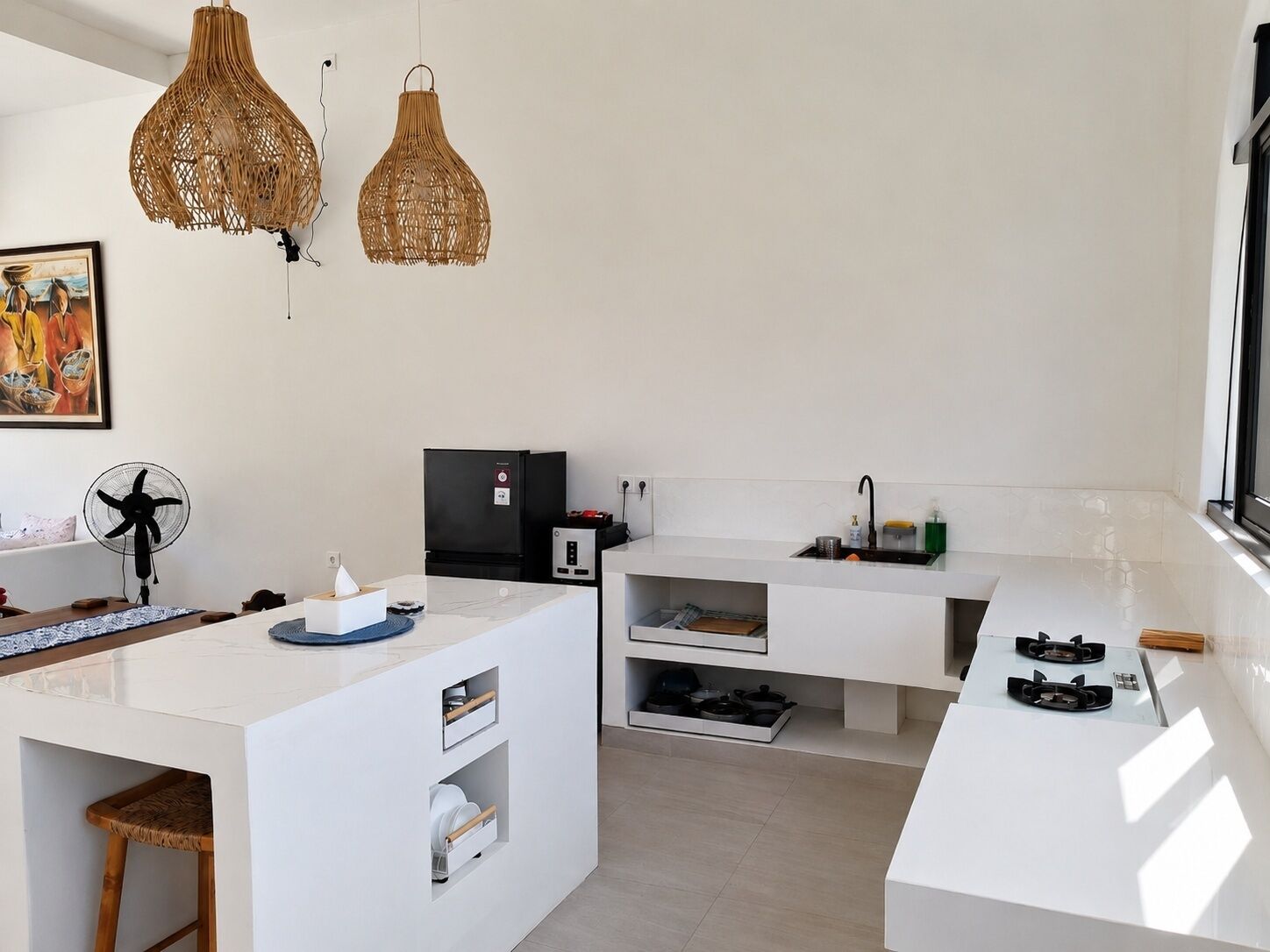 A modern kitchen with a white countertop, built-in appliances, and a large window.