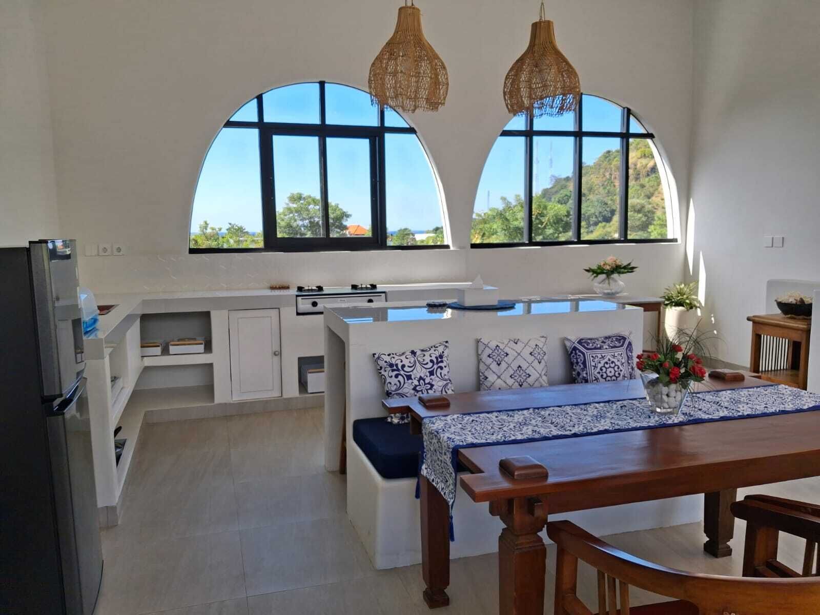 Una cocina moderna con comedor, ventanas amplias y vistas al exterior.