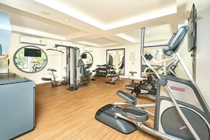 A gym with cardio equipment, weight machines, and a mirror. - 2BR condo w/ pools, gym & balcony, steps to beach (Playa del Carmen)
