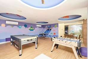 A room with a foosball table, a pool table, and a reclining chair. - 2BR condo w/ pools, gym & balcony, steps to beach (Playa del Carmen)