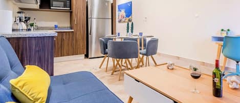 A modern living room with a sofa, dining table, and chairs.