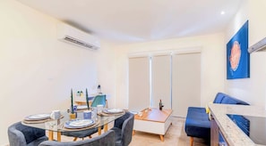 A modern dining area with a glass table, chairs, and a kitchen counter. - Veranto condo near 5th Ave w/ pool access (Playa del Carmen)