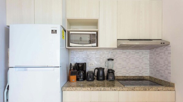 A kitchen with a white refrigerator, a microwave, a coffee maker, and a blender on the counter. - Ocean-view studio w/ gym, pool & balcony (Playa del Carmen)