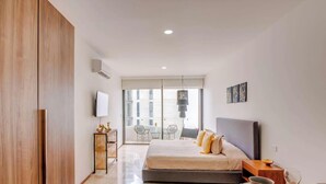 Un dormitorio con cama, mesita de noche y vistas al exterior.