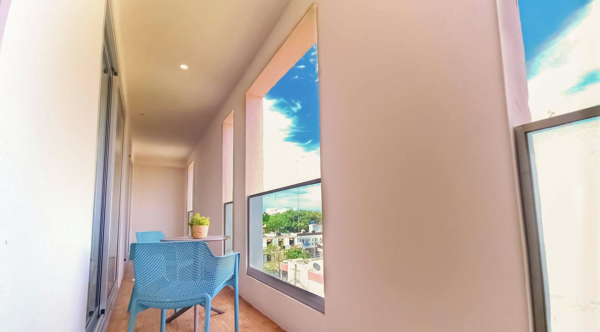 Un balcón con vista a edificios y un cielo despejado.