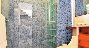 A bathroom with mosaic tile walls, a glass shower enclosure, and wooden cabinetry. - Exclusive Spa Tub & BBQ Balcony, 2 Blocks to Beach (Playa del Carmen)
