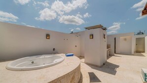 A modern outdoor bathroom with a large bathtub, a shower, and a toilet. - Coastal oasis w/ spa tub near beach & 5th Ave (Playa del Carmen)