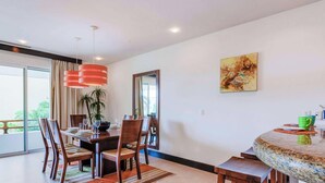 A dining area with a round table, chairs, and a large mirror. - Penthouse w/ private terrace & rooftop pool (Playa del Carmen)