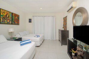 A hotel room with two beds, a flat-screen TV, a dresser, and artwork on the walls. - Penthouse retreat | rooftop, BBQ & pool (Playa del Carmen)
