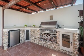 An outdoor kitchen with a built-in grill, a refrigerator, and a sink. - Penthouse retreat | rooftop, BBQ & pool (Playa del Carmen)