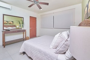 A bedroom with a bed, a dresser, a mirror, a ceiling fan, and a wardrobe. - 2BR condo - pool, BBQ & beach steps away (Playa del Carmen)
