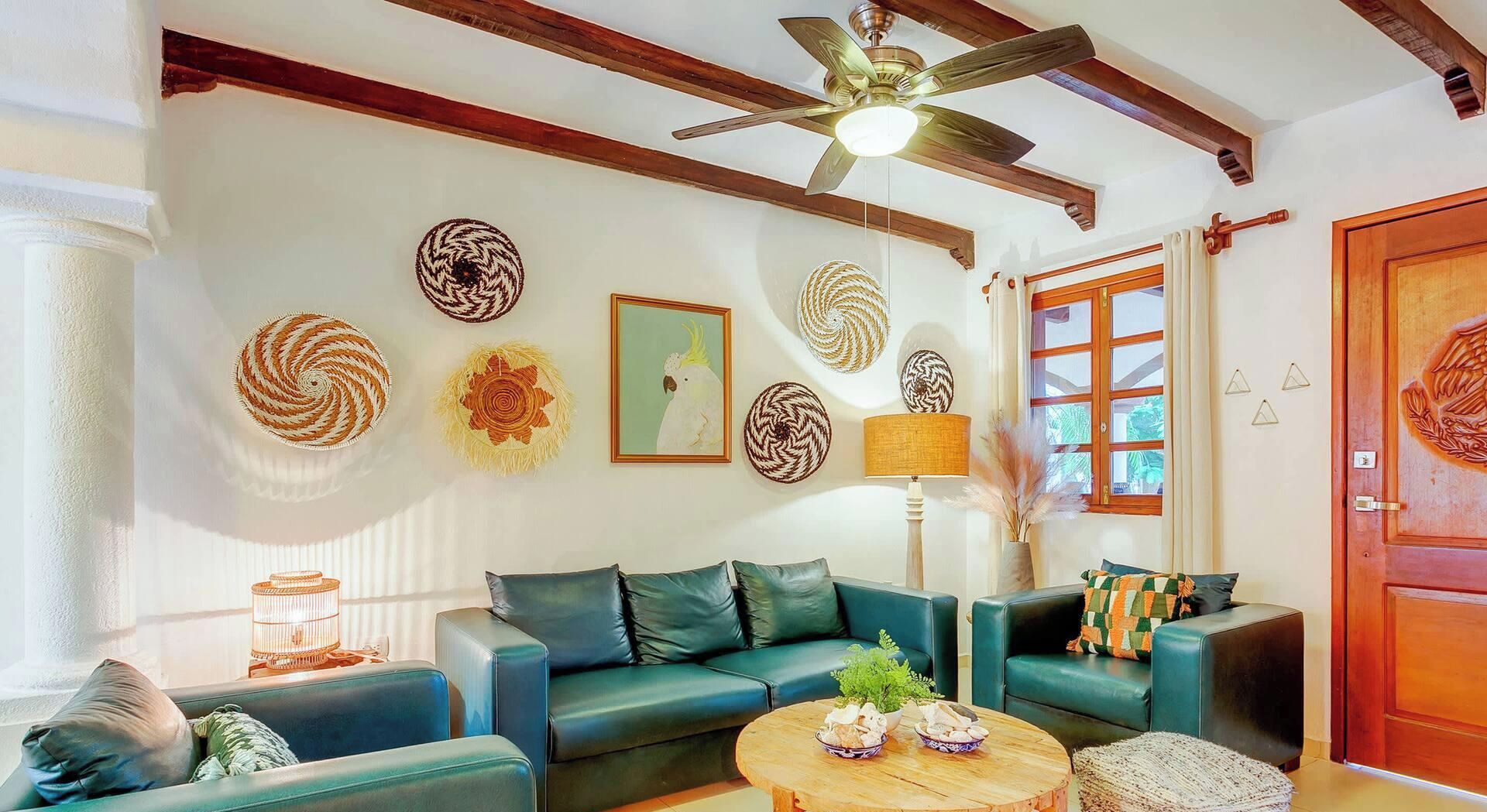 Una sala de estar con un sofá verde, una mesa de centro de madera y arte decorativo en la pared.