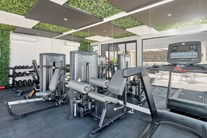 A gym with various exercise equipment, including a treadmill, weight machines, and dumbbells. - Coastal escape w/ rooftop pool, gym & beach walk (Playa del Carmen)