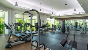 Et fitnesscenter med løbebånd, crosstrainere og styrkeudstyr.
