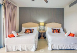Une chambre d’hôtel avec deux lits, chacun doté d’une tête de lit, d’oreillers et d’une table de chevet avec une lampe.
