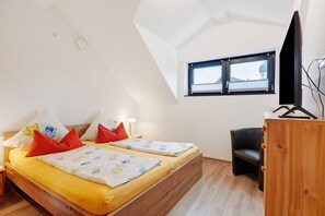 A bedroom with two beds, a TV, a desk, and a window with a view. - Deluxe Apartment Lea with Balcony and Wi-Fi (Radolfzell am Bodensee)
