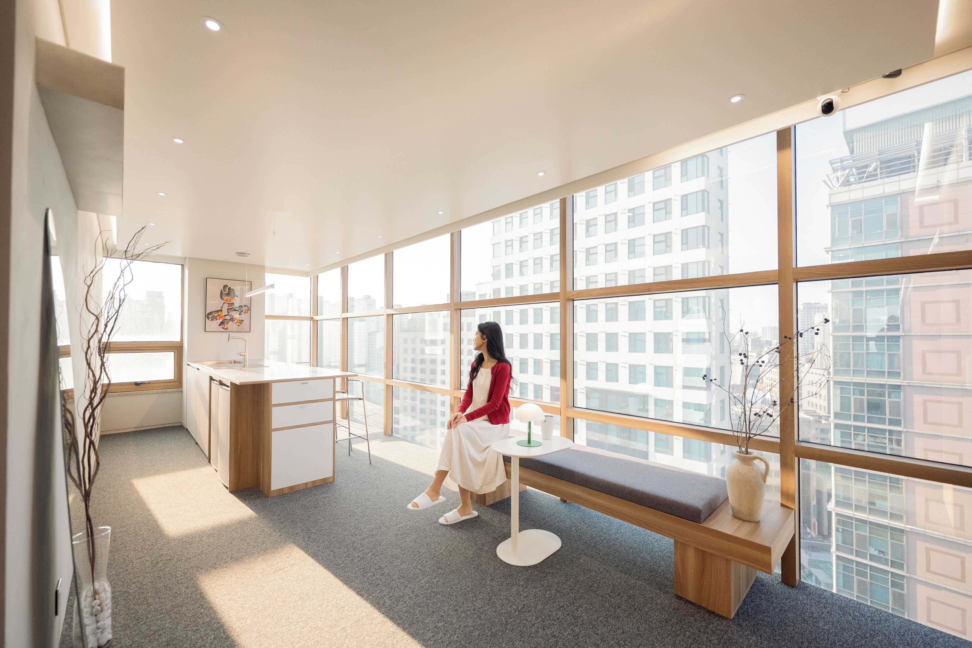 A modern interior with a large window, a bench, and a desk.