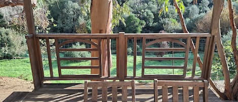 A wooden deck with a view of a lush green landscape.