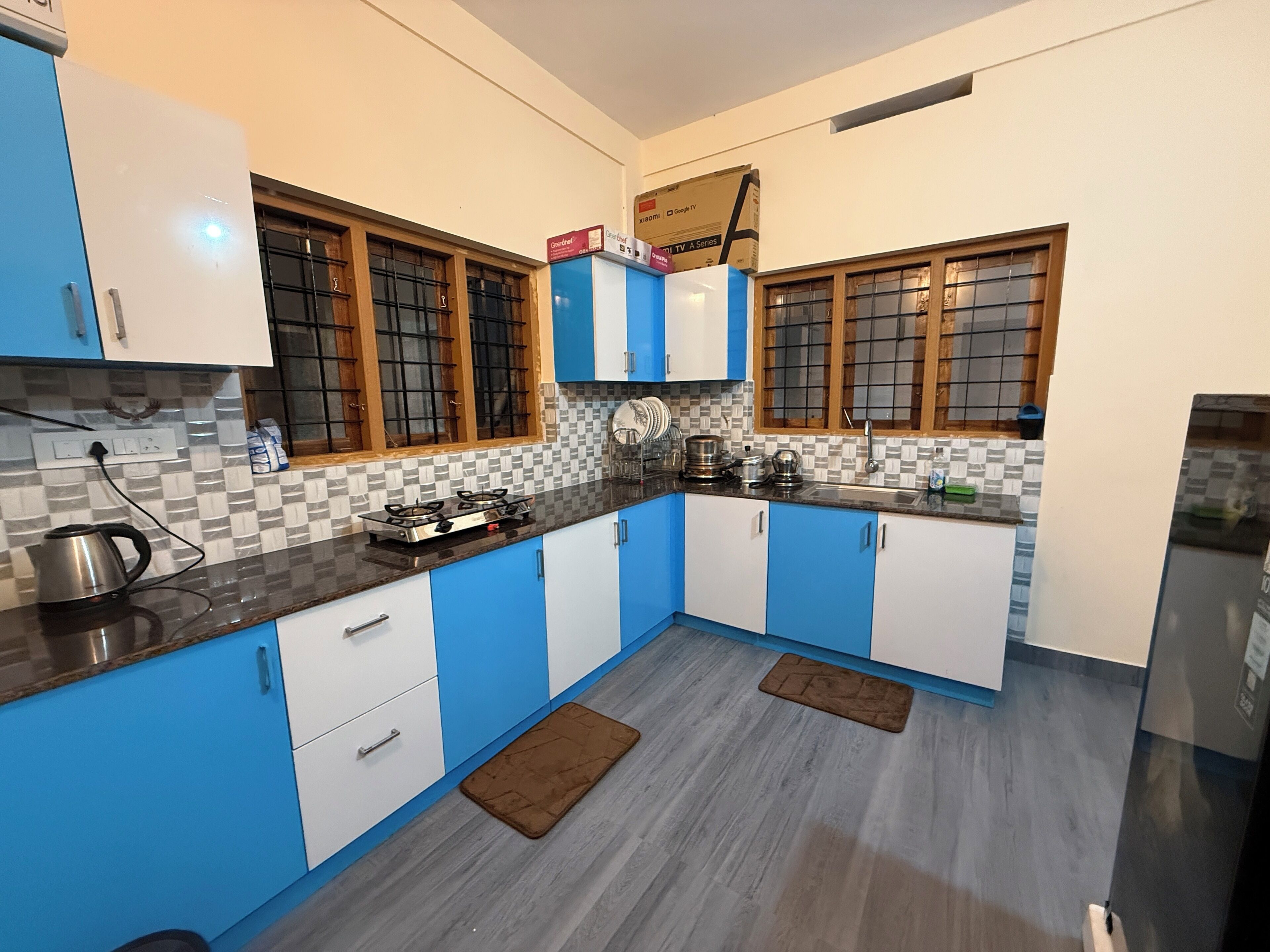 Una cocina moderna con armarios azules y blancos, una estufa a gas y un microondas.