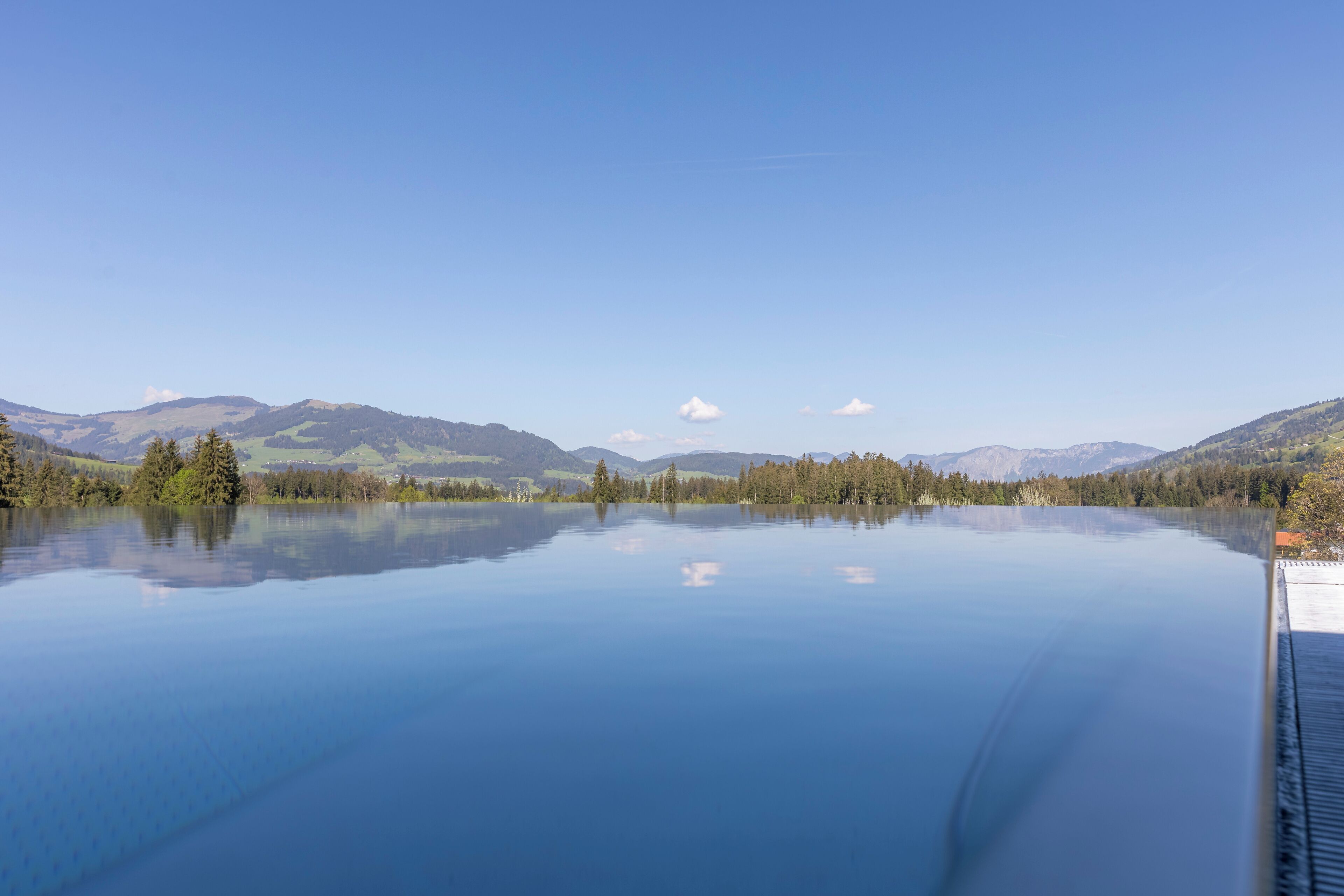 Un lac paisible dont les eaux reflètent clairement les montagnes et les arbres environnants.