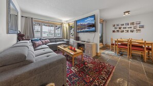A modern living room with a gray sectional sofa, a wooden coffee table, and a fireplace. - Nestle Inn Hideaway - Toby Creek Lodge Unit 213 (Area F (Columbia Lake/Windermere Lake))