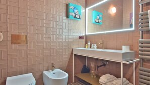 Un bagno moderno con bidet, lavandino con specchio e porta asciugamani.