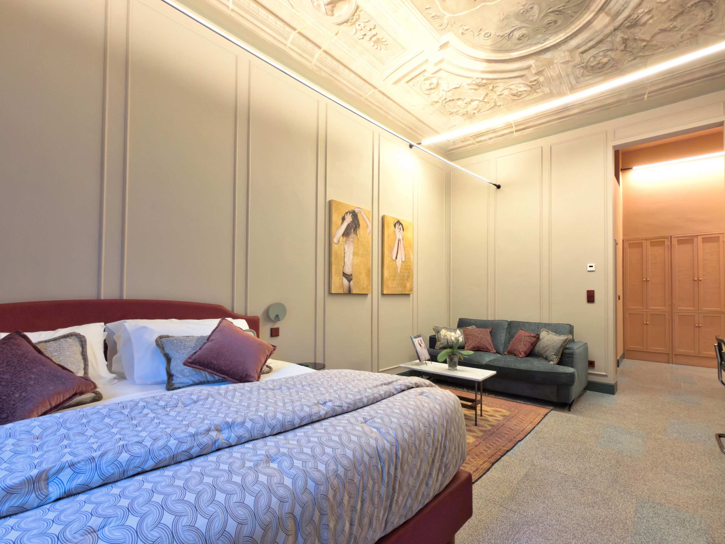 Une chambre à coucher avec un lit, un canapé et une porte.