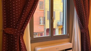 Ein Zimmer mit Fenster, Vorhängen und einer Klimaanlage.