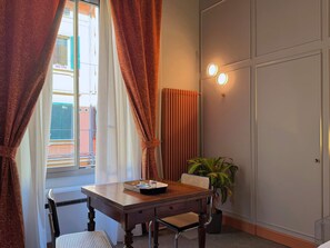 A room with a wooden table, a chair, a potted plant, and a radiator. - Cinisca Suite Blue - In Bologna with style (Bologna)